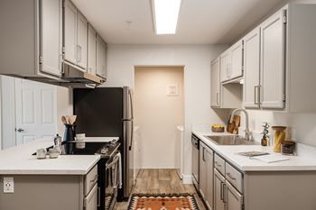 Galley kitchen with white countertops and modern cabinetry
